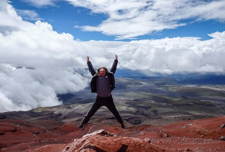 A man jumping while posing for pictures in the mountains in South America