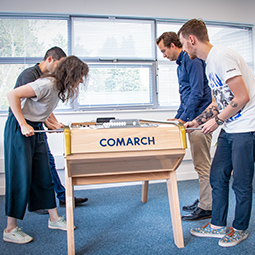 Four young people play foosball