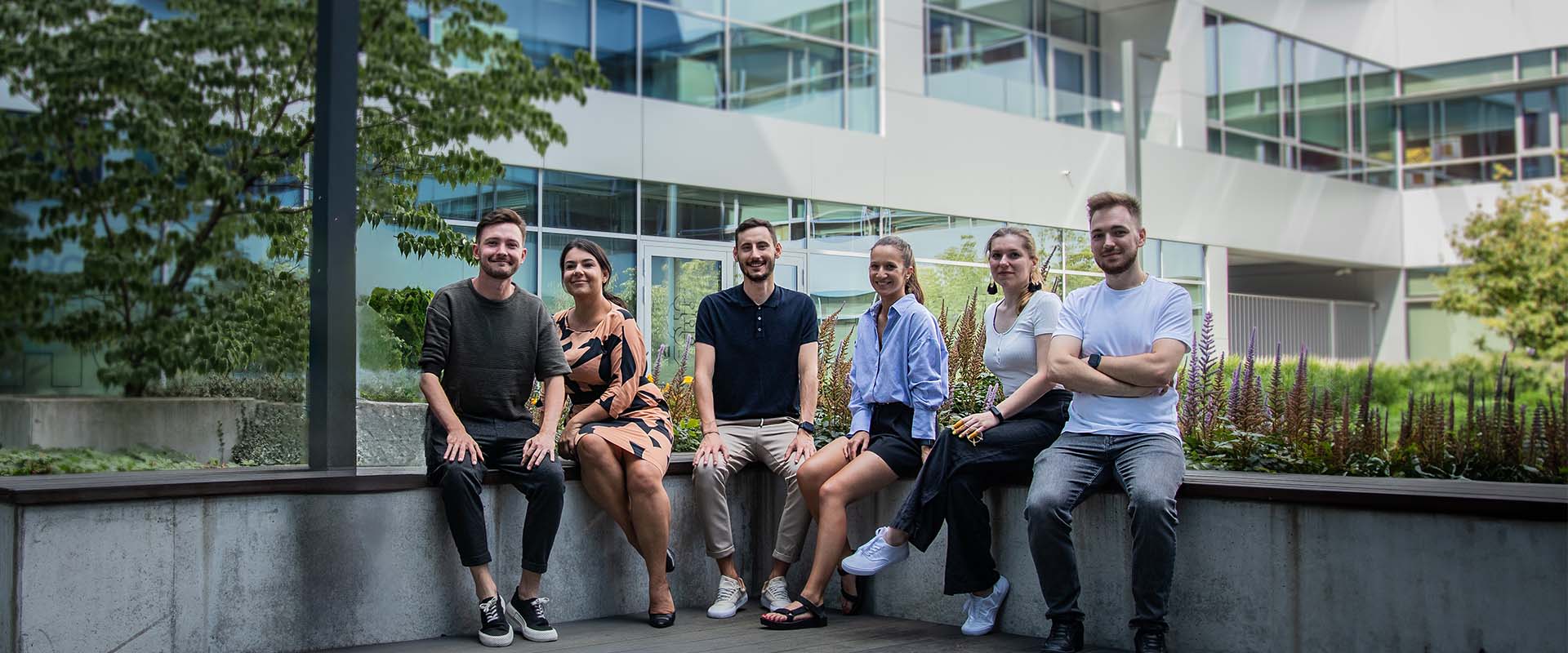 People posing, smiling, sitting on a bench.