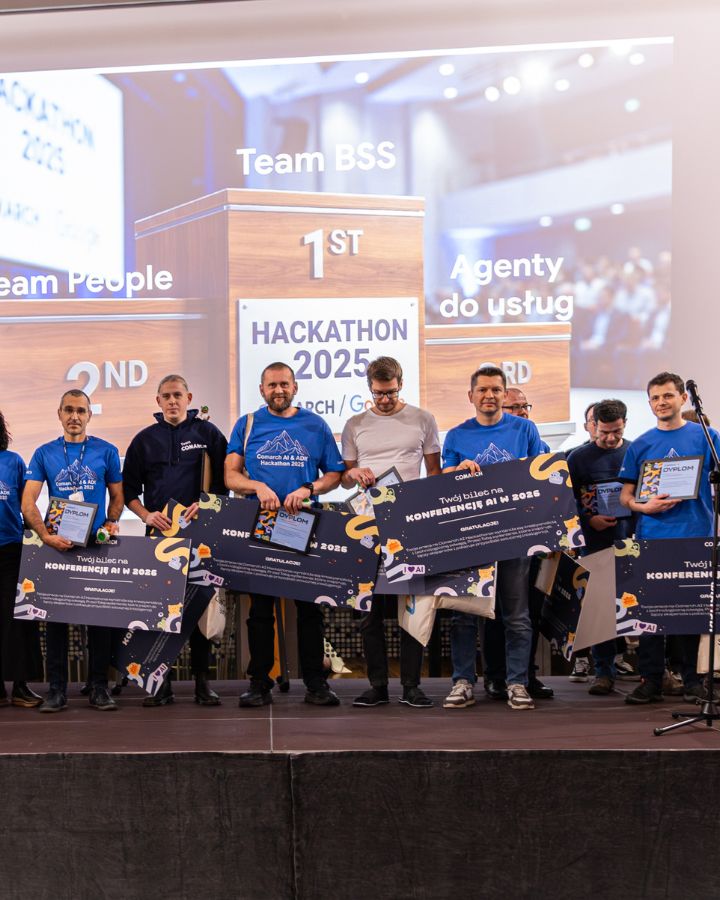 Winners of the "Hackathon 2025" on stage holding commemorative certificates and tickets for an AI conference in 2026.