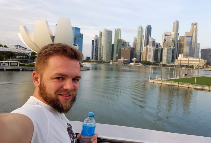 A young man takes a picture during a trip to Singapore